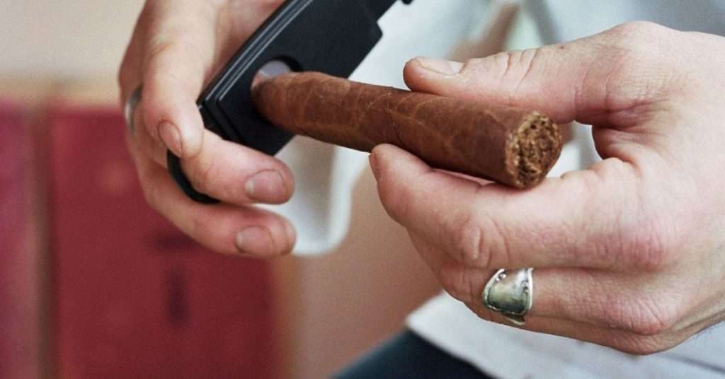 man cutting a cigar