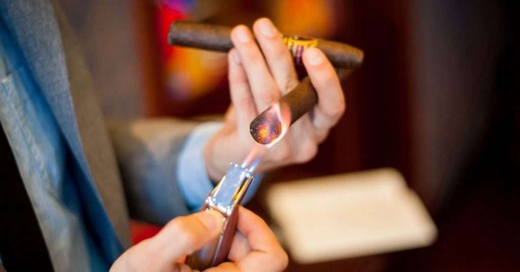 man lighting a cigar
