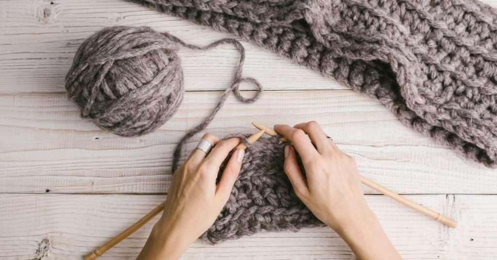 hands knitting with ball of yarn