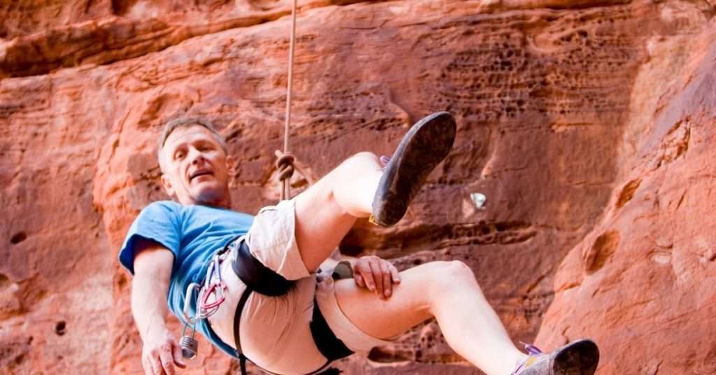man rappelling hanging by a rope