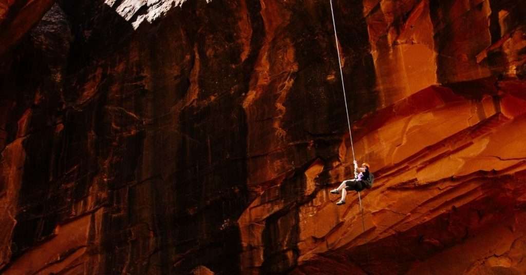 rappelling down cliff face